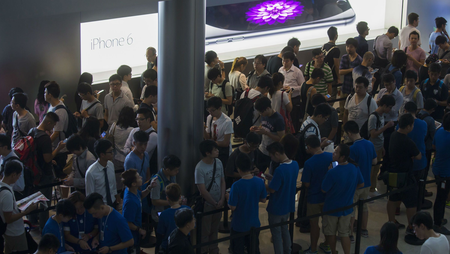 Customers stand in a line on the first day of sale for the iPhone 6 and iPhone 6 Plus, outside the Apple store in Hong Kong