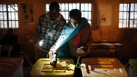 A woman (R) is helped by an electoral agent (L) to cast her vote in the general elections at a polling station in Moipei in Kajiado County, some 80km south of the capital Nairobi, Kenya, 08 August 2017. Kenyans are casting their votes to elect their leaders in general elections where incumbent President and the leader of the ruling Jubilee coalition Uhuru Kenyatta is being challenged by popular opposition leader Raila Odinga who leads The National Super Alliance (NASA) coalition. Many fear the possibility of the post-election violence.
