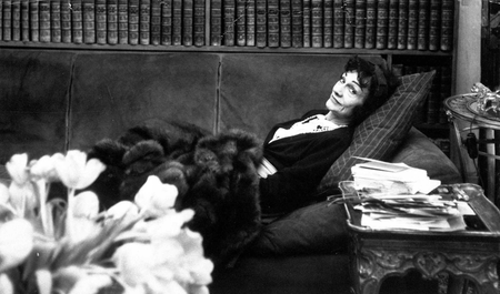 Gabrielle &quot;Coco&quot; Chanel, back in the fashion world after a lapse of 15 years, relaxes in her book-lined studio above her Paris salon April 21,1954.