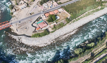 Aerial photo of a river running alongside a settlement in Lima, Peru