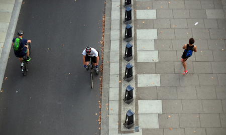 Cyclists pass a jogger along the Embankment during the morning rush hour in central London