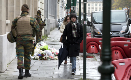 Belgian Army soldiers patrol next to flowers left outside of the French Consulates office in Brussels Saturday, Nov. 21, 2015. Belgium raised it security level to it&#039;s highest degree on Saturday as the manhunt continues for extremist Salah Abdeslam who took part in the Paris attacks.