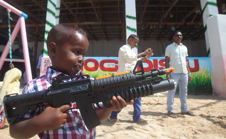 A Somali boy plays with a toy gun after prayers on the first day of Eid al-Adha in Somalia&#039;s capital Mogadishu, September 24, 2015. Muslims around the world celebrate Eid al-Adha to mark the end of the haj pilgrimage by slaughtering sheep, goats, camels and cows to commemorate Prophet Abraham&#039;s willingness to sacrifice his son, Ismail, on God&#039;s command.