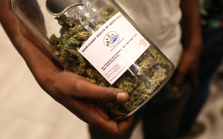 A man holds a jar full of cannabis buds at a 2018 expo in South Africa.