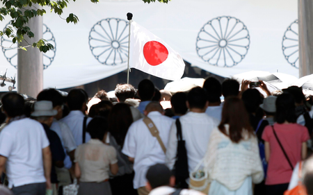 A Japan&#039;s national flag flutters among visitors at the Yasukuni Shrine in Tokyo August 15, 2014, on the 69th anniversary of Japan&#039;s surrender in World War Two. Japanese Prime Minister Shinzo Abe on Friday sent a ritual offering to the Tokyo shrine to war dead but did not join senior government officials in a visit, a decision meant to avoid inflaming ties with Beijing as he seeks a Sino-Japanese summit.