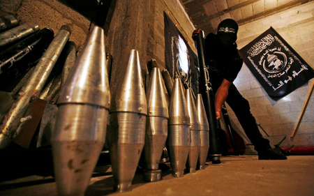 ** FILE ** In this file photo from Monday, Sept. 15, 2008, a Palestinian militant from the Al Nasser Brigades, an armed wing of the Popular Resistance Committees with ties to the Islamic group Hamas, shows the explosive tips of homemade rockets during a display at a storage facility in Gaza City. Most of the Hamas rockets targeted at Israel are thrown together in small metal shops in densely populated areas of Gaza. But a growing number are more sophisticated, longer-range weapons, believed put together from parts thought to originate in Syria or Iran, and smuggled in through Egyptian tunnels. Despite that new capacity, Hamas is still far beyond another anti-Israeli militant group, Hezbollah, in its rocket capabilities.