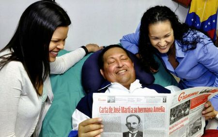 Hugo Chávez with his daughters, holding a copy of Granma.
