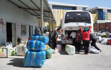 The shoppers stuff their purchases onto the shuttle bus, preparing to leave Khorgos ICBC.