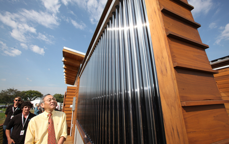 U.S. Energy Secretary Steven Chu tours the University of Maryland&#039;s entry in the U.S. Department of Energy Solar Decathlon, followed by students Scott Tjaden, left, and Jeff Rappaport, second from left, in Washington, D.C., Friday, Sept. 30, 2011. (Credit: Stefano Paltera/U.S. Department of Energy Solar Decathlon)