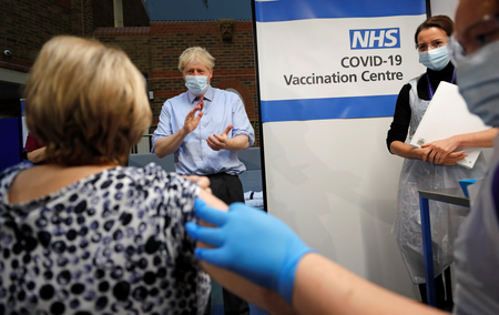 British prime minister Boris Johnson claps after a nurse administers the Pfizer/BioNTech Covid-19 vaccine.