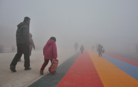 Parents walk primary school students to school amid thick haze in Chiping county, Shandong province