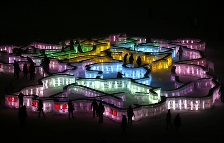 People visit a maze which was built by ice bricks and illuminated by coloured lights during a trial operation ahead of the 31st Harbin International Ice and Snow Festival in the northern city of Harbin, Heilongjiang province, January 4, 2015. The winter festival will be officially opened on January 5, 2015. REUTERS/Kim Kyung-Hoon