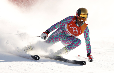 A downhill skier turning and spraying snow.