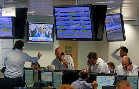 Politician Nigel Farage who backed Britain&#039;s leave, is seen on TV as traders in London find themselves in a Frenzy. (Reuters/Russell Boyce)