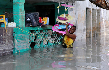 A resident evacuates furniture after rain water flooded his home in Mogadishu, Somalia May 21, 2018.