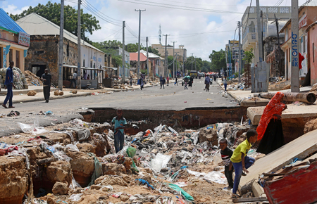 Children play near a road destroyed by rain water that flooded their street in Mogadishu, Somalia May 21, 2018.