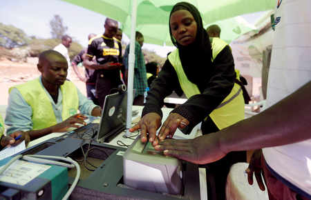 Officials from the Independent Electoral and Boundaries Commission (IEBC) records finger prints of a man as they collect data from the electorate during the launch of the 2017 general elections voter registration exercise within Kibera slums in Kenya&#039;s capital Nairobi, January 16, 2017.