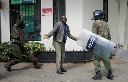 Kenyan policemen beat a protester during clashes in Nairobi on May 16th.