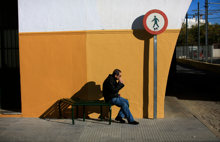 A man sits on a bench as he eats a sandwich at El Prado de San Sebastian coach station in the Andalusian capital of Seville