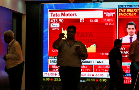 A man gestures past a a screen displaying news of markets update inside the Bombay Stock Exchange (BSE) building in Mumbai, India, June 24. (Reuters/Danish Siddiqui)