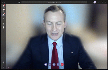 Man on video call with blurred background.