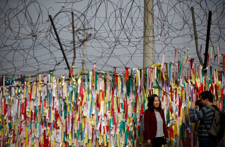 A barbed wire fence decorated with South Korean national flags is pictured near the demilitarized zone which separates North and South Korea in Paju October 31, 2014. On the 25th anniversary of the fall of the Berlin Wall, there are still barriers separating communities around the world, from the barbed wire fence dividing the two Koreas, the fence around the Spanish enclave of Melilla, to the sectarian Peace Wall in Belfast, the Israel-Gaza barrier and the border separating Mexico from the United States. Picture taken October 31, 2014. REUTERS/Kim Hong-Ji (SOUTH KOREA - Tags: ANNIVERSARY CIVIL UNREST POLITICS SOCIETY) ATTENTION EDITORS: PICTURE 19 OF 28 FOR WIDER IMAGE PACKAGE &#039;THE WALLS THAT DIVIDE&#039; TO FIND ALL IMAGES SEARCH &#039;WALLS DIVIDE&#039; - RTR4D2WC