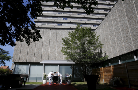 An occupational therapist and a physiotherapist work with a patient, who had suffered a stroke, during a media presentation in the 300-square-metre therapeutic garden of the Acute Neurological Rehabilitation Unit at Lausanne University Hospital (CHUV) in Lausanne, Switzerland, August 25, 2015. Doctors at the facility say they see a significant improvement in patients with brain injuries when they are exposed to stimulation in an outdoor environment as part of their rehabilitation, and plan to share their findings on Wednesday at a seminar of neuroscience specialists. Picture taken August 25, 2015. REUTERS/Denis Balibouse
