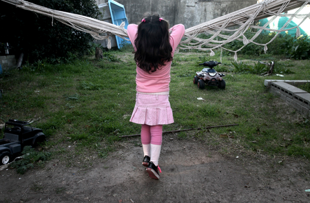 Lulu, a transgender girl, leans on a hammock at her home in Buenos Aires July 25, 2013. Lulu, a six-year-old Argentine child who was listed as a boy at birth, has been granted new identification papers by the Buenos Aires provincial government listing her as a girl. According to her mother Gabriela, Lulu chose the gender as soon as she first learned to speak. Gabriela said her child, named Manuel at birth, insisted on being called Lulu since she was just four years old, local media reported. Argentina in 2012 put in place liberal rules on changing gender, allowing people to alter their gender on official documents without first having to receive a psychiatric diagnosis or surgery. Picture taken on July 25, 2013. REUTERS/Stringer (ARGENTINA - Tags: SOCIETY HEALTH) - RTX141CN