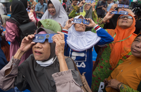 Muslim women watch the eclipse at at the campus of the Faculty of Astronomy of Muhammadiah University of North Sumatra