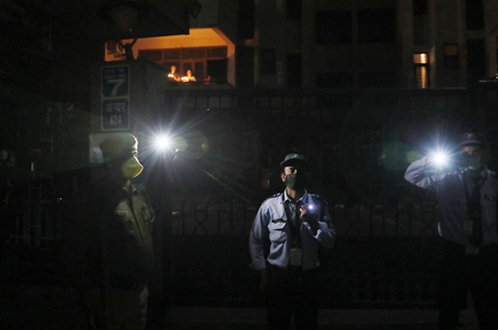 Those on duty and with no access to candles improvised with flashlights on their mobile phones, like these security guards in New Delhi.