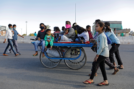 A migrant worker rides a cart with his family on a highway as they return to their villages, during a 21-day nationwide lockdown to limit the spreading of coronavirus disease (COVID-19), in Ghaziabad