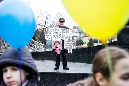 A protestor during Unity Day celebrations with posters blaming everything on Hitler, Putin, and the Jews.