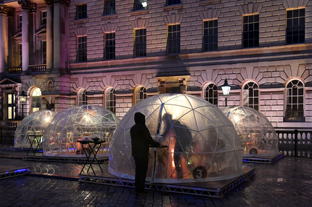 Staff deliver meals at a Winter Dome - outdoor dining pods erected for the month of December in the courtyard of Somerset House to enable restaurant eating, as English second lockdown restrictions were lifted amid the spread of the coronavirus disease (COVID-19), Britain, December 3, 2020. Picture taken December 3, 2020. REUTERS/Toby Melville