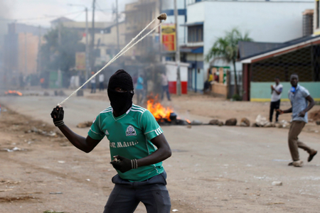 A supporter of Kenyan opposition leader Raila Odinga throws stones during a protest in Kisumu.