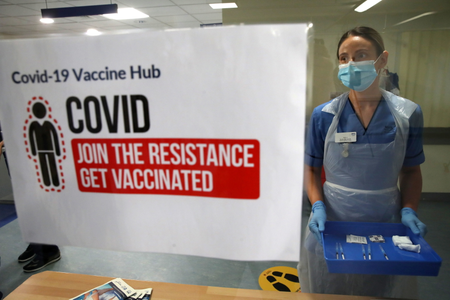 Deputy charge nurse Katie McIntosh stands in front of a sign that reads, &quot;Join the resistance, get vaccinated.&quot;