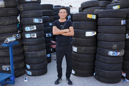 Beka stands in front of his tire store in Khorgos ICBC.