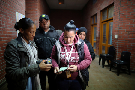 An electoral official checks the identity document of a voter in Cape Town in 2019.