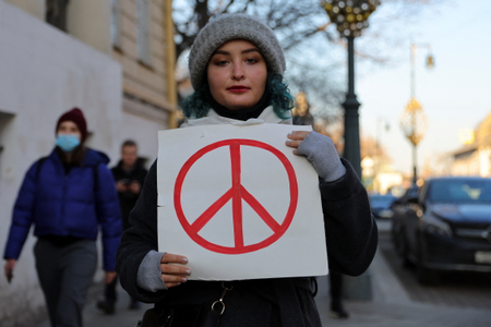 A person holds a white poster with a paper with a peace sign during a protest against Russian invasion of Ukraine in Moscow