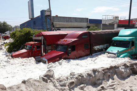 Trucks are buried in ice after a heavy storm of rain and hail which affected some areas of Guadalajara