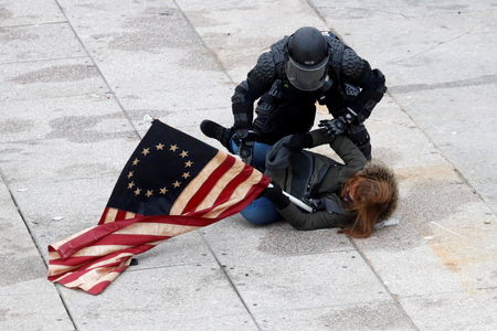 A police officer detains a pro-Trump protester as mobs storm the U.S. Capitol, during a rally to contest the certification of the 2020 U.S. presidential election results by the U.S. Congress, at the U.S. Capitol Building in Washington, U.S, January 6, 2021.