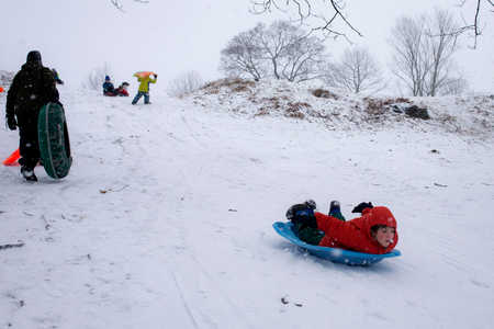 A boy sleds down a hill