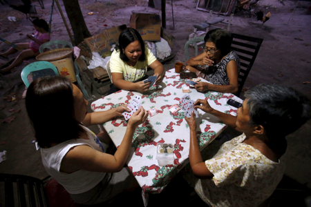 Women play a Russian poker card game in Angeles city, north of Manila.