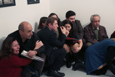 People crouch in a corner after Andrei Karlov, the Russian Ambassador to Turkey, was shot at a photo gallery in Ankara, Turkey on Dec.19,2016. Karlov, 62, was several minutes into a speech at an embassy-sponsored photo exhibition when a man fired a gun at him. Karlov was rushed to a hospital after the attack and later died from his gunshot wounds. (AP Photo/Burhan Ozbilici)