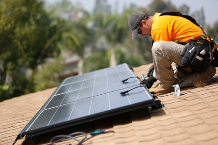Vivint Solar technician Eduardo Aguilar installs solar panels on the roof of a house in Mission Viejo, California October 25, 2013.