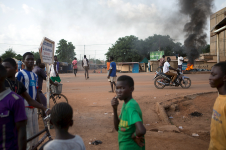 Anti-coup protesters stand next to burning tires in Ouagadougou.