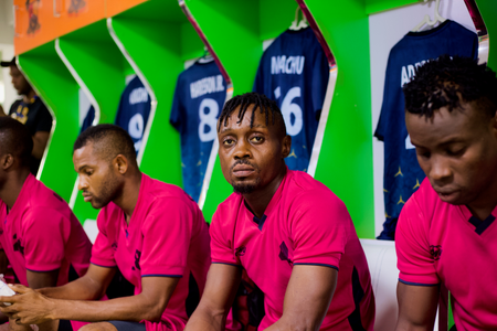 Sporting Lagos players dressed in pink while seated in their locker room before their first official game