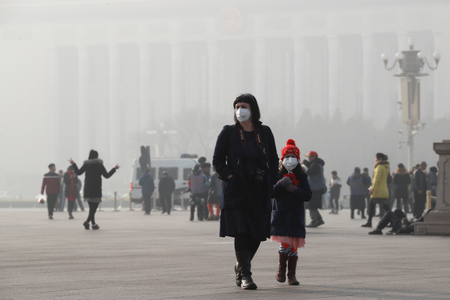 A foreign tourist and a child wearing protection masks walk through Tiananmen Square in Beijing as the capital of China is blanked by heavy smog on Wednesday, Jan. 4, 2017. China has long faced some of the worst air pollution in the world, blamed on its reliance of coal for energy and factory production, as well as a surplus of older, less efficient cars on its roads. Inadequate controls on industry and lax enforcement of standards have worsened the pollution problem. (AP Photo/Andy Wong)