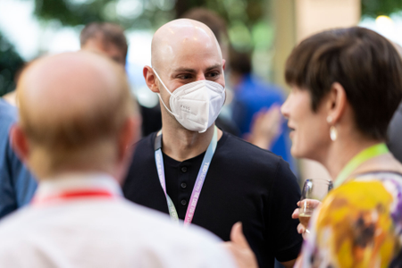 Attendees wearing face mask mingle with those without facial coverings