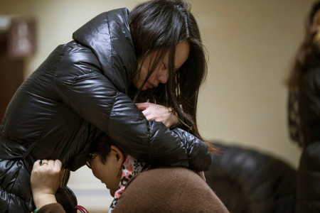Relatives of a victim hug as they wait at a hospital where injured people of a stampede incident are treated.