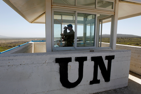 UN peacekeeping soldier, Australian Army Captain Morris uses binoculars from an observation tower located on the Israeli side of the 1973 Golan Heights ceasefire line with Syria